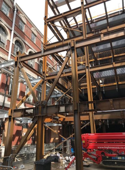 The new steel frame abuts existing structures along three elevations