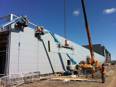 Installation of heavy cladding panels (Image courtesy of Duggan Steel)