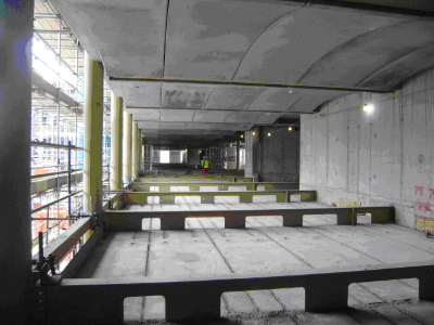 Exposed concrete floors supported on steel beams and used to provide thermal mass