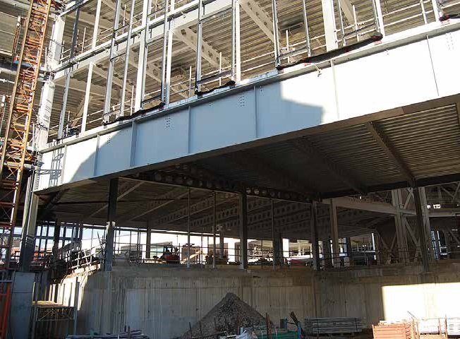 A large plate girder supports four storeys above a service yard