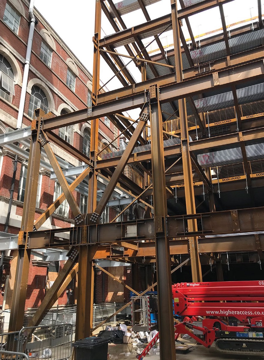 The new steel frame abuts existing structures along three elevations