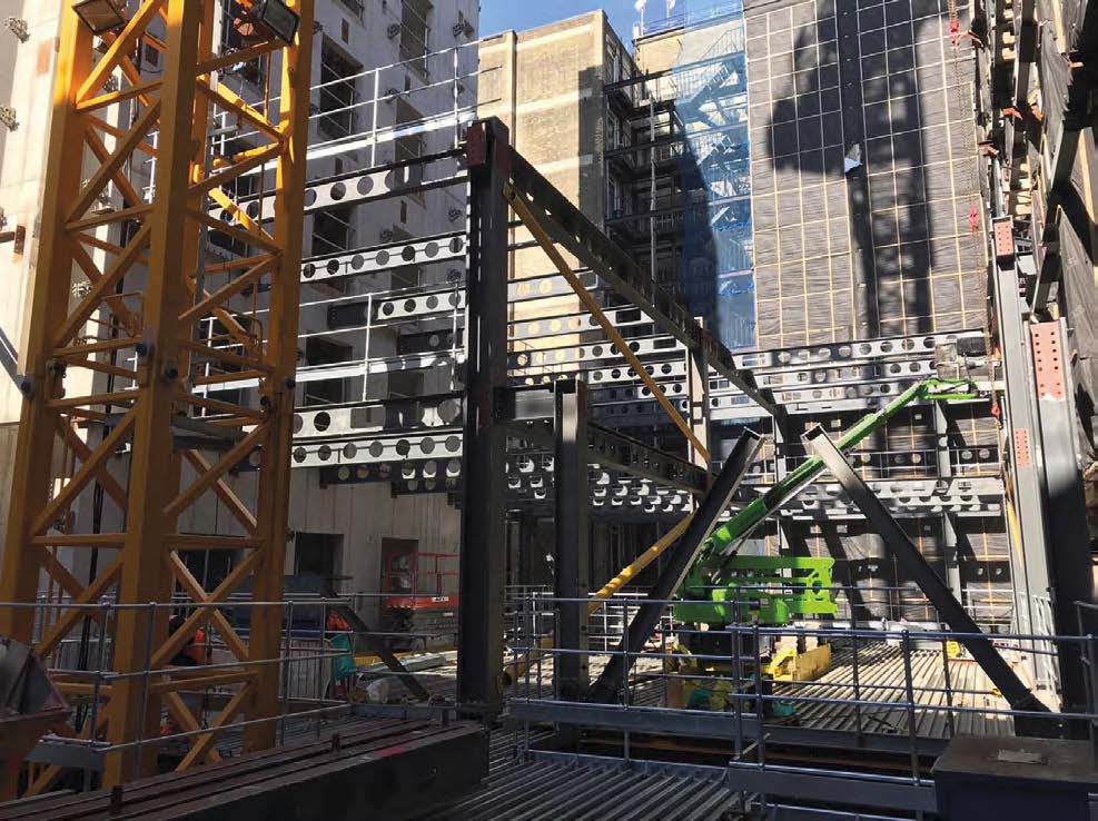 Within the retained façade, a steelwork structure is being erected