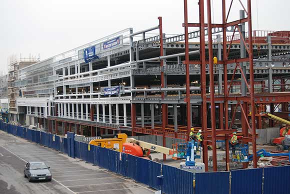 The project is surrounded by roads and an existing car park