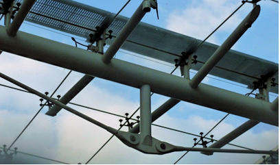Tie acting as the tension chord of a roof beam to support glazing