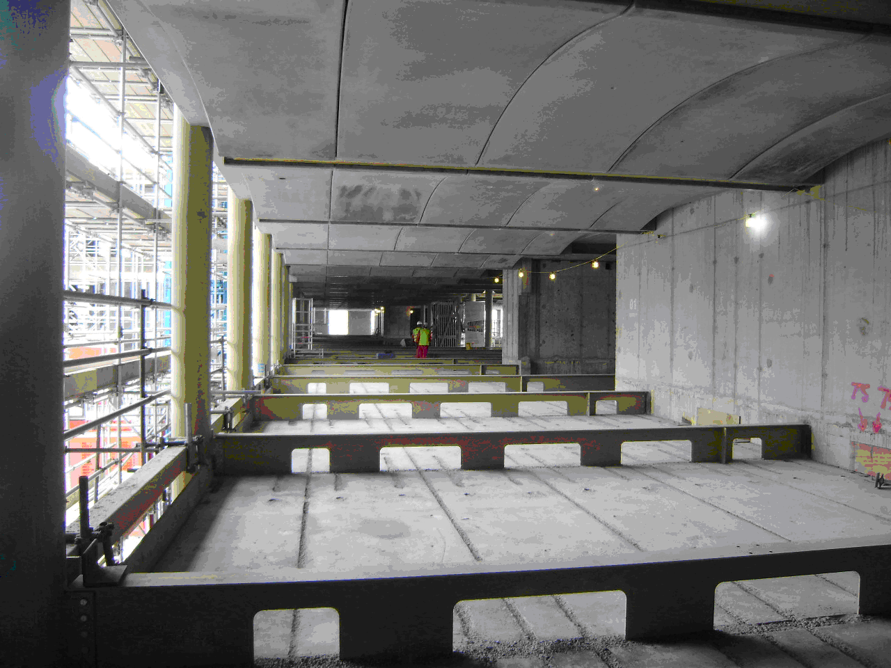 Exposed concrete floors supported on steel beams and used to provide thermal mass