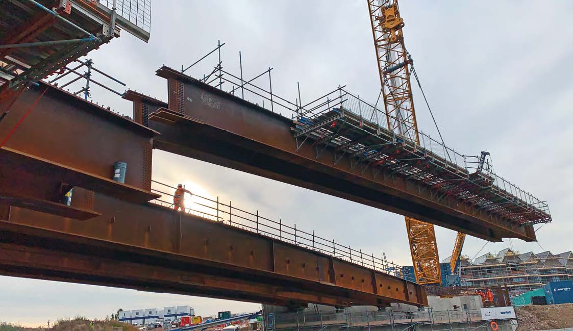 The bridge&#39;s final pair of girders is lifted into place