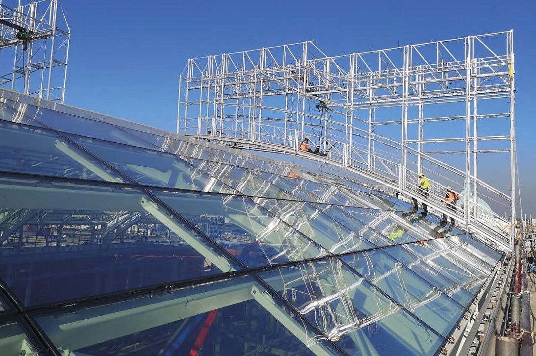 Glazing installation proceeds on the steel-framed roof