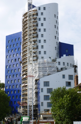 Installation of lightweight facade system attached to a modular building through a mast climbing system. (Image courtesy of Futureform)