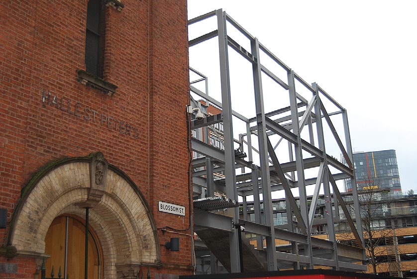 The steel frame connects to the existing church building