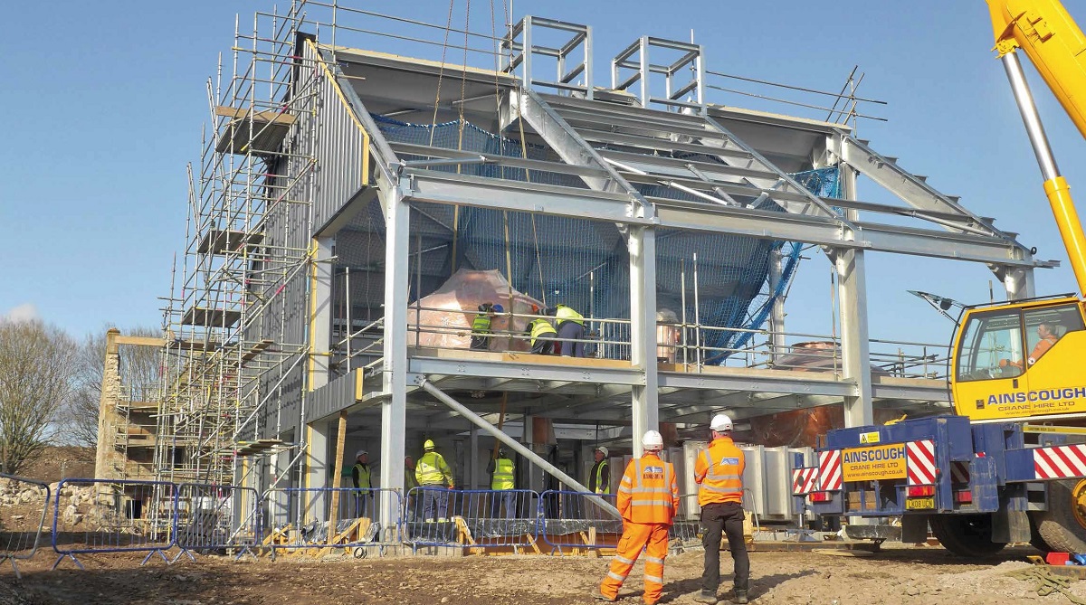 Copper tanks are lowered into position through holes in the steelwork