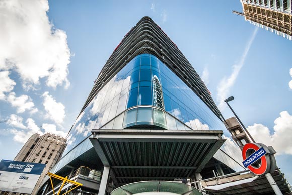 Part of the building is positioned over an entrance to Aldgate East Underground Station