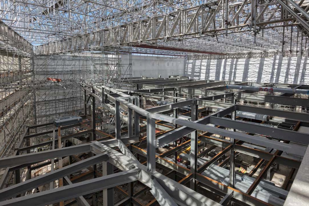 A scaffold system spans the project, helping to keep the site watertight, and supports two gantry cranes