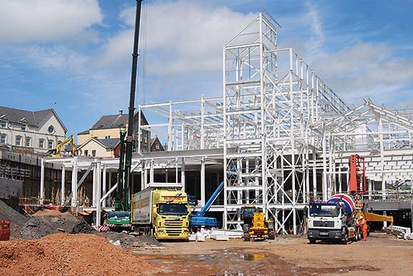 A large truss forms the roof of the main retail floor and supports the piled wall